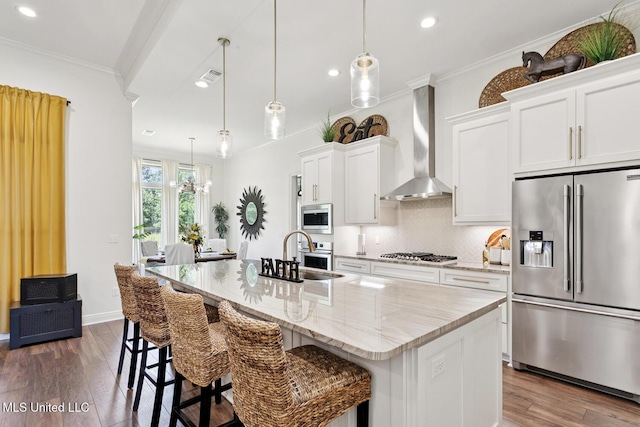 111 Jefferson Davis Pkwy, Picayune, MS 39466 - kitchen with appliances with stainless steel finishes, wall chimney exhaust hood, recessed lighting, an island with sink, and dark wood-style flooring