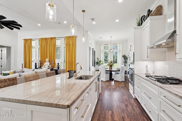 111 Jefferson Davis Pkwy, Picayune, MS 39466 - kitchen with a sink, appliances with stainless steel finishes, wall chimney exhaust hood, a large island with sink, and white cabinets