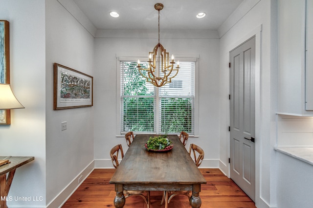 dining area with a notable chandelier and hardwood / wood-style flooring