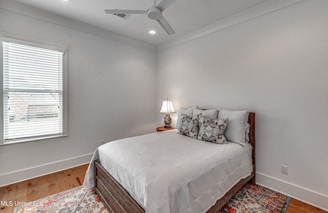 bedroom with ornamental molding, hardwood / wood-style flooring, and ceiling fan