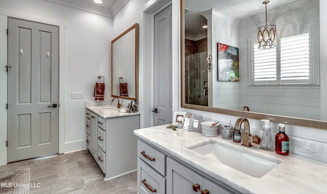 bathroom with vanity, an inviting chandelier, a shower, and crown molding