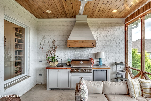 interior space featuring premium range hood, butcher block countertops, wood ceiling, and stainless steel refrigerator