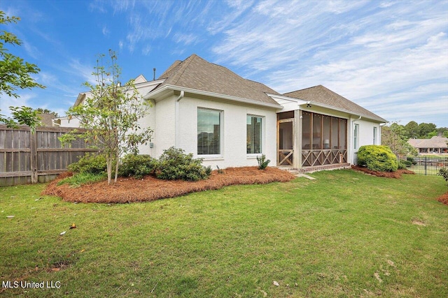 back of property featuring a yard and a sunroom