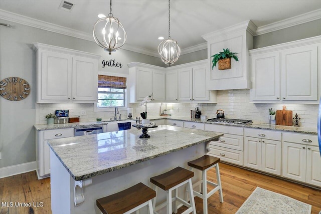 kitchen featuring stainless steel appliances, light wood-type flooring, a kitchen island, and white cabinets