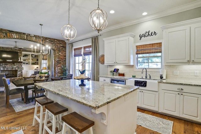 kitchen with white cabinets, hardwood / wood-style floors, a kitchen bar, pendant lighting, and a center island