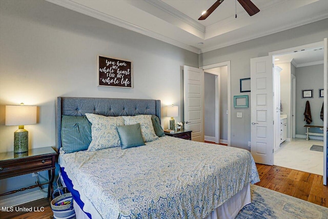 bedroom featuring ceiling fan, ornamental molding, a raised ceiling, and wood finished floors