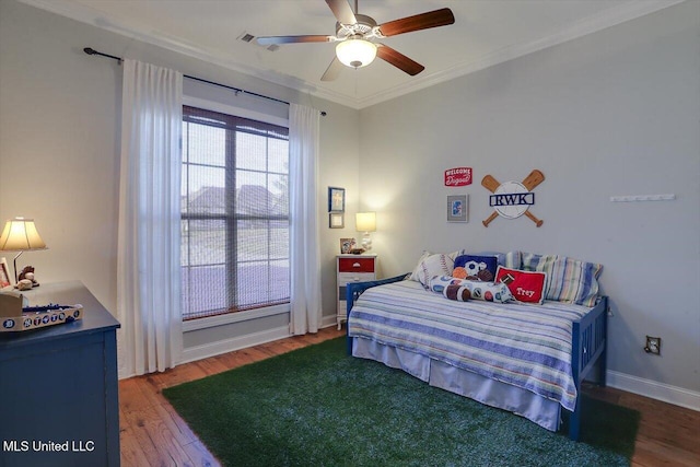 bedroom featuring crown molding, visible vents, a ceiling fan, wood finished floors, and baseboards