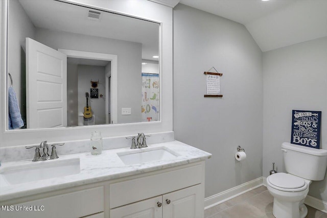 bathroom featuring toilet, lofted ceiling, vanity, and tile patterned floors