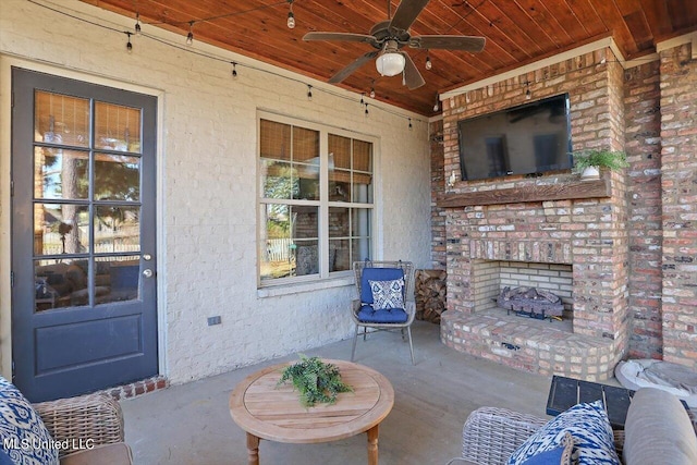 view of patio / terrace featuring ceiling fan and a brick fireplace