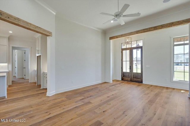 interior space featuring ornamental molding, a wealth of natural light, baseboards, and light wood finished floors