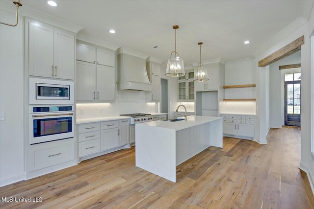 kitchen featuring white oven, custom exhaust hood, light countertops, a sink, and built in microwave