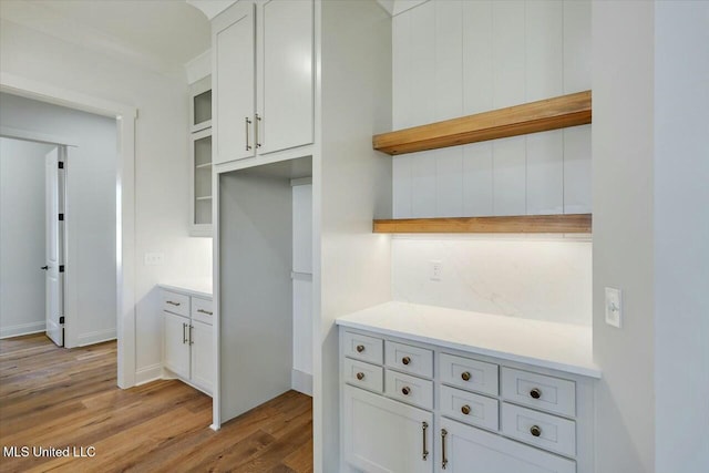 kitchen featuring open shelves, light wood-style flooring, light countertops, and white cabinetry