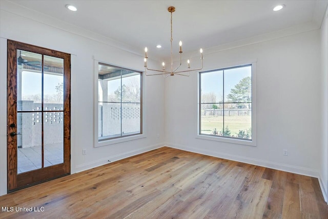 spare room with ornamental molding, light wood-style flooring, and baseboards