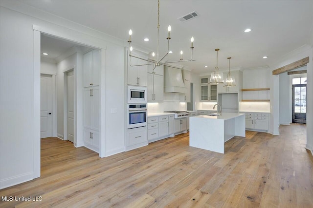 kitchen featuring premium range hood, white cabinets, light countertops, appliances with stainless steel finishes, and pendant lighting