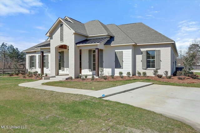 view of front of house with metal roof, a front lawn, a standing seam roof, and roof with shingles