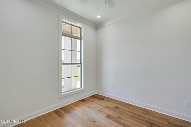 spare room with recessed lighting, light wood-type flooring, a ceiling fan, and baseboards