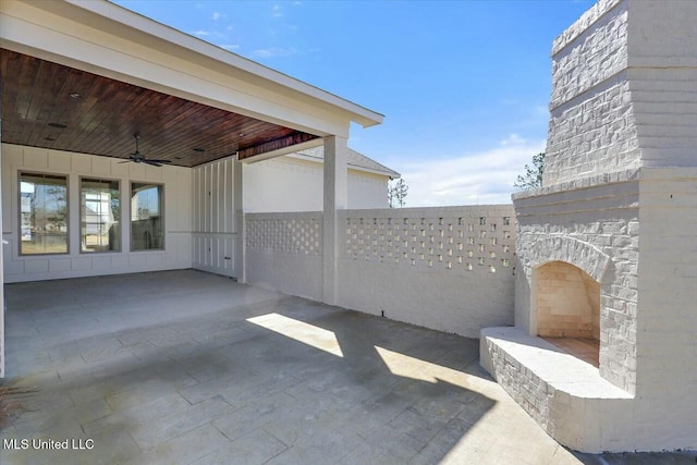 view of patio / terrace with a carport, ceiling fan, and fence