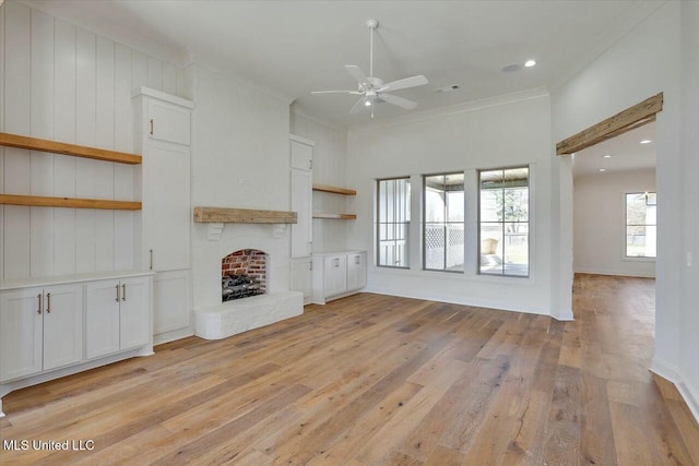 unfurnished living room with visible vents, a ceiling fan, light wood-style floors, ornamental molding, and a brick fireplace