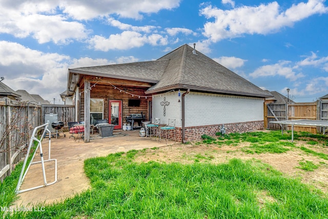 back of house with a patio and a trampoline