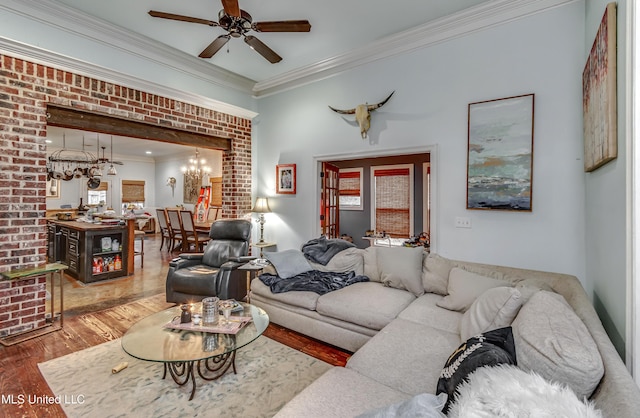 living room with crown molding, hardwood / wood-style flooring, and ceiling fan with notable chandelier