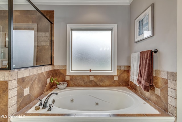 bathroom with crown molding and tiled bath