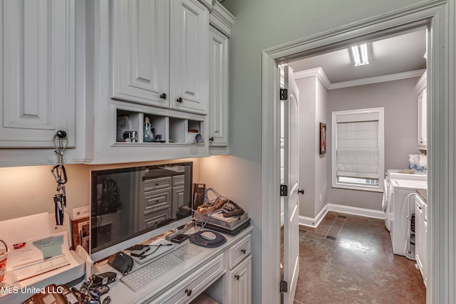 kitchen featuring washer and clothes dryer, ornamental molding, and white cabinets