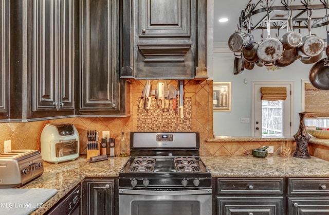 kitchen with backsplash, dark brown cabinets, and stainless steel gas range