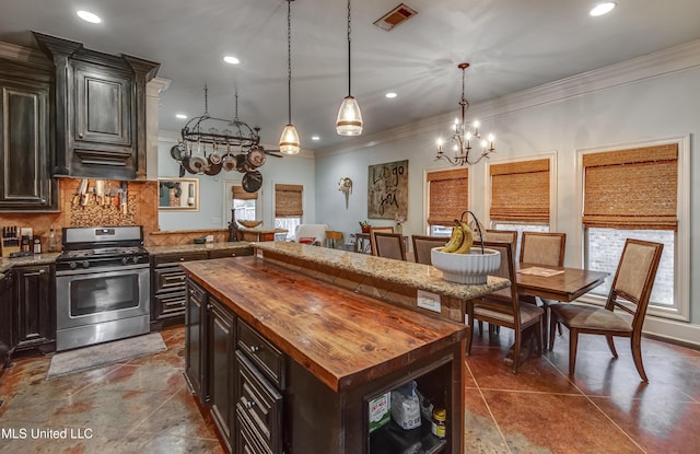 kitchen with a kitchen island, butcher block countertops, hanging light fixtures, dark brown cabinetry, and gas stove