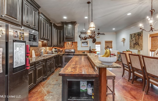 kitchen featuring decorative light fixtures, backsplash, a center island, light stone counters, and stainless steel appliances