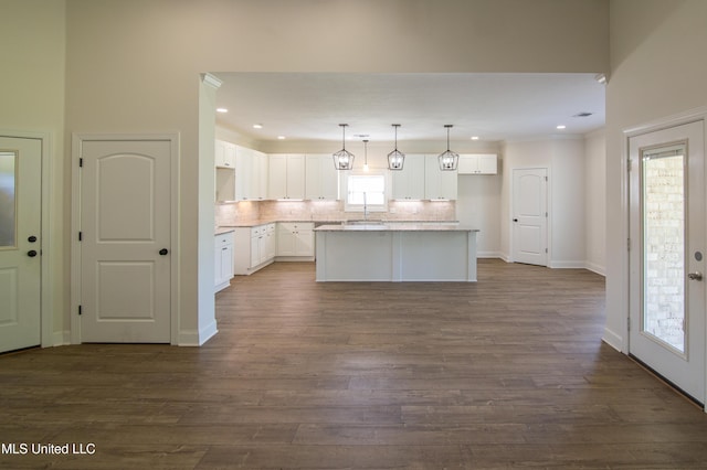 163 Frye Cir, Caledonia, MS 39740 - kitchen with a kitchen island, decorative backsplash, dark wood-style floors, white cabinetry, and pendant lighting