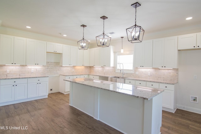 163 Frye Cir, Caledonia, MS 39740 - kitchen with a sink, wood finished floors, a center island, white cabinets, and ornamental molding