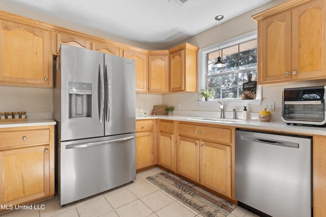 kitchen with sink, light brown cabinets, stainless steel appliances, decorative light fixtures, and light tile patterned floors