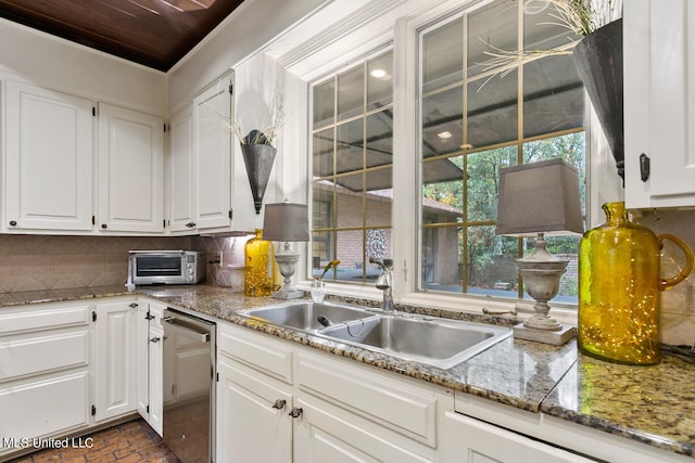 kitchen with decorative backsplash, white cabinetry, light stone countertops, dishwasher, and sink