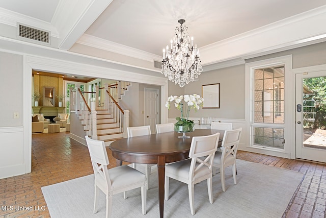 dining space featuring beamed ceiling, ornamental molding, and an inviting chandelier