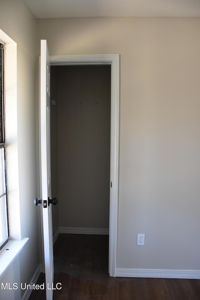 interior space with dark wood-type flooring and baseboards