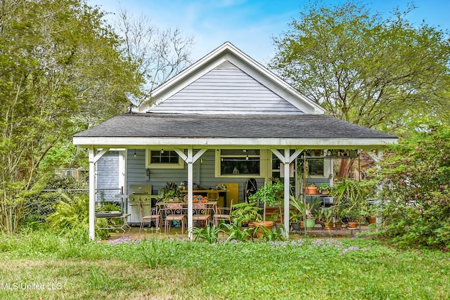exterior space featuring a shingled roof, a patio, and a yard