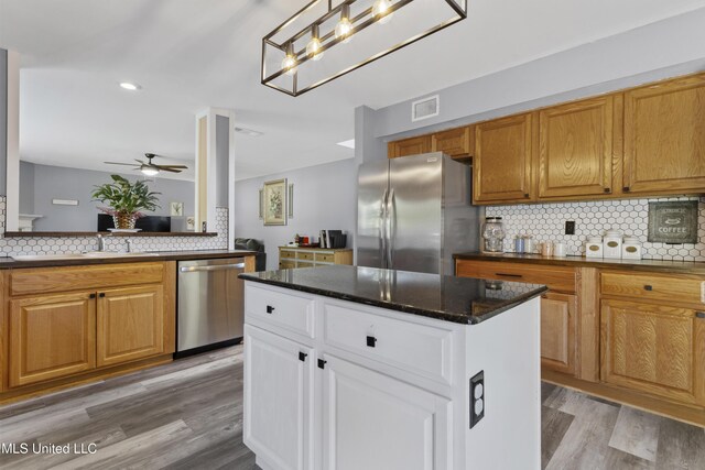 11222 Cypress Bayou Dr, Gulfport, MS 39503 - kitchen featuring light wood-style flooring, ceiling fan, visible vents, stainless steel appliances, and backsplash