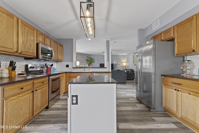 11222 Cypress Bayou Dr, Gulfport, MS 39503 - kitchen featuring tasteful backsplash, stainless steel appliances, light wood-style floors, ceiling fan, and a center island