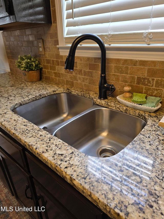 447 Shaker Dr, Senatobia, MS 38668 - details with dark brown cabinets, light stone counters, backsplash, and a sink