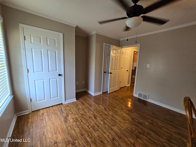 447 Shaker Dr, Senatobia, MS 38668 - unfurnished bedroom with dark wood-type flooring, visible vents, crown molding, and baseboards