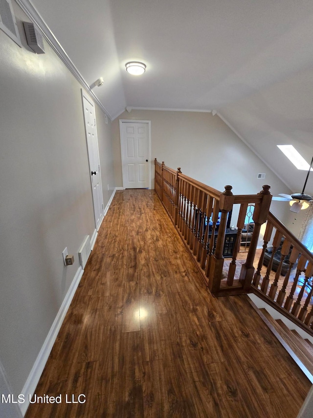 447 Shaker Dr, Senatobia, MS 38668 - corridor featuring lofted ceiling with skylight, baseboards, visible vents, and dark wood-style floors