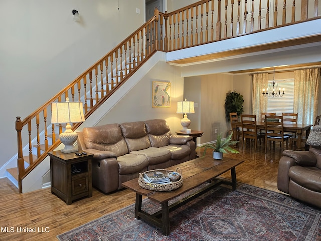 447 Shaker Dr, Senatobia, MS 38668 - living area with a chandelier, wood finished floors, a towering ceiling, baseboards, and stairs
