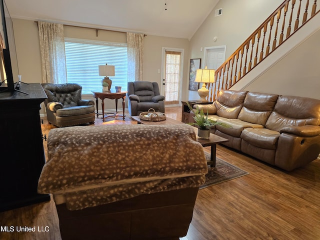 447 Shaker Dr, Senatobia, MS 38668 - living room with high vaulted ceiling, visible vents, stairs, and wood finished floors