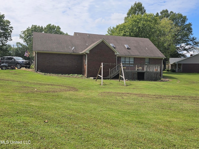 447 Shaker Dr, Senatobia, MS 38668 - back of house featuring brick siding, stairs, a lawn, and a wooden deck