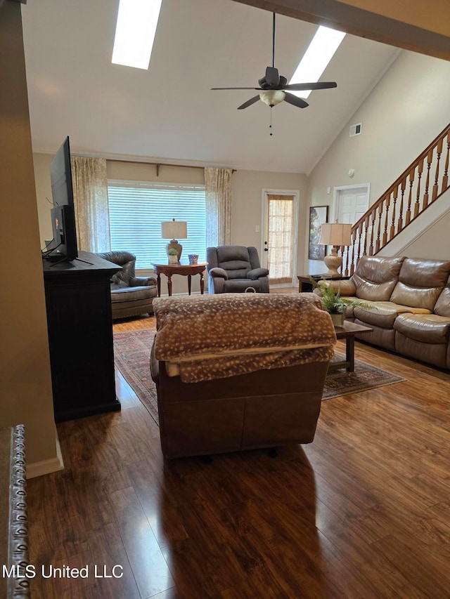 447 Shaker Dr, Senatobia, MS 38668 - living area featuring a skylight, dark wood finished floors, ceiling fan, stairway, and high vaulted ceiling