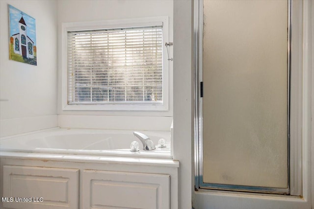 bathroom with a healthy amount of sunlight and independent shower and bath