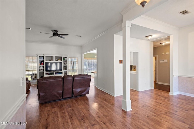 living room featuring hardwood / wood-style floors, ceiling fan, and crown molding