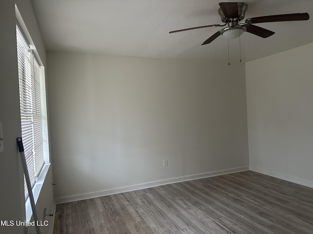 unfurnished room with a ceiling fan, baseboards, and wood finished floors