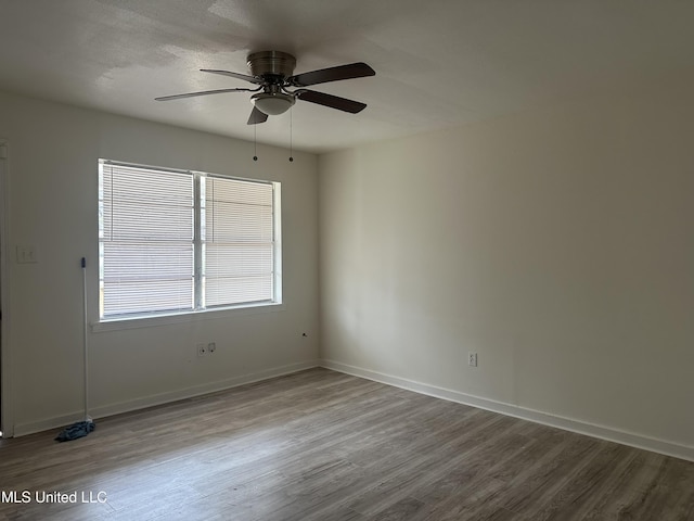 spare room featuring a textured ceiling, wood finished floors, baseboards, and ceiling fan