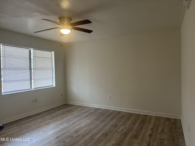 unfurnished room with a ceiling fan, baseboards, and wood finished floors